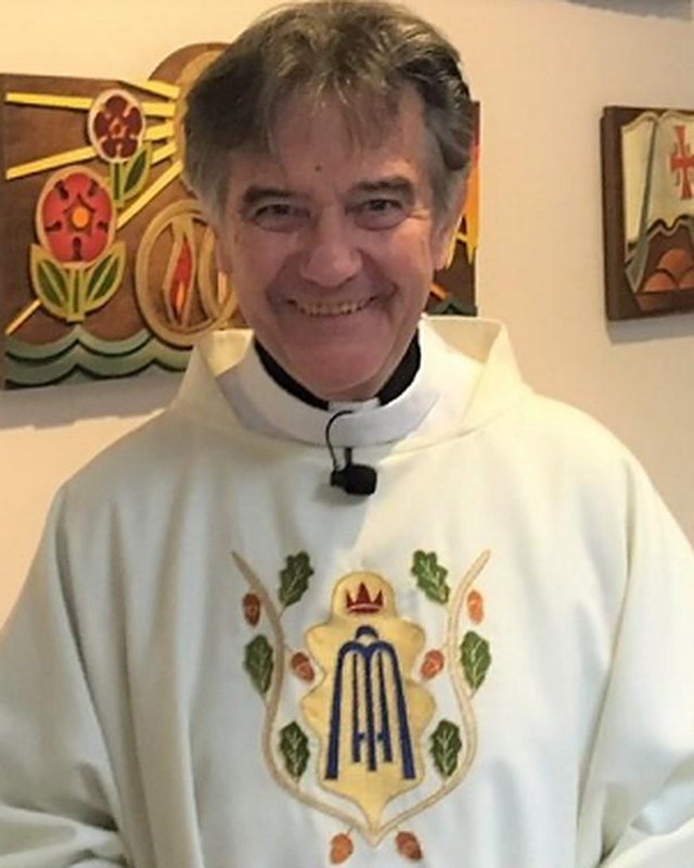 Fr. Danny Murphy smiling, in a cream chasuble with a Marian emblem.